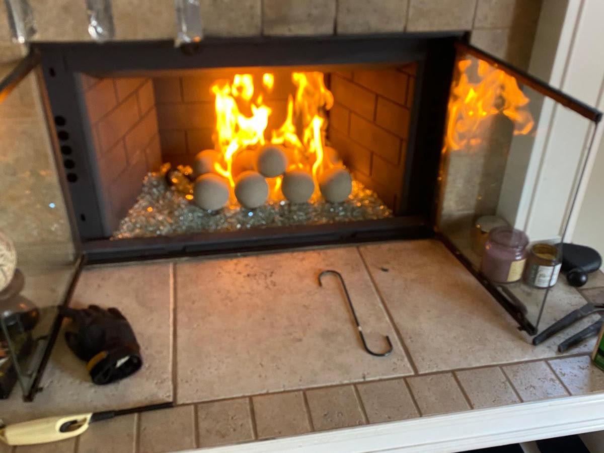 Restored fireplace with a fire burning after a GB Home Services chimney sweep