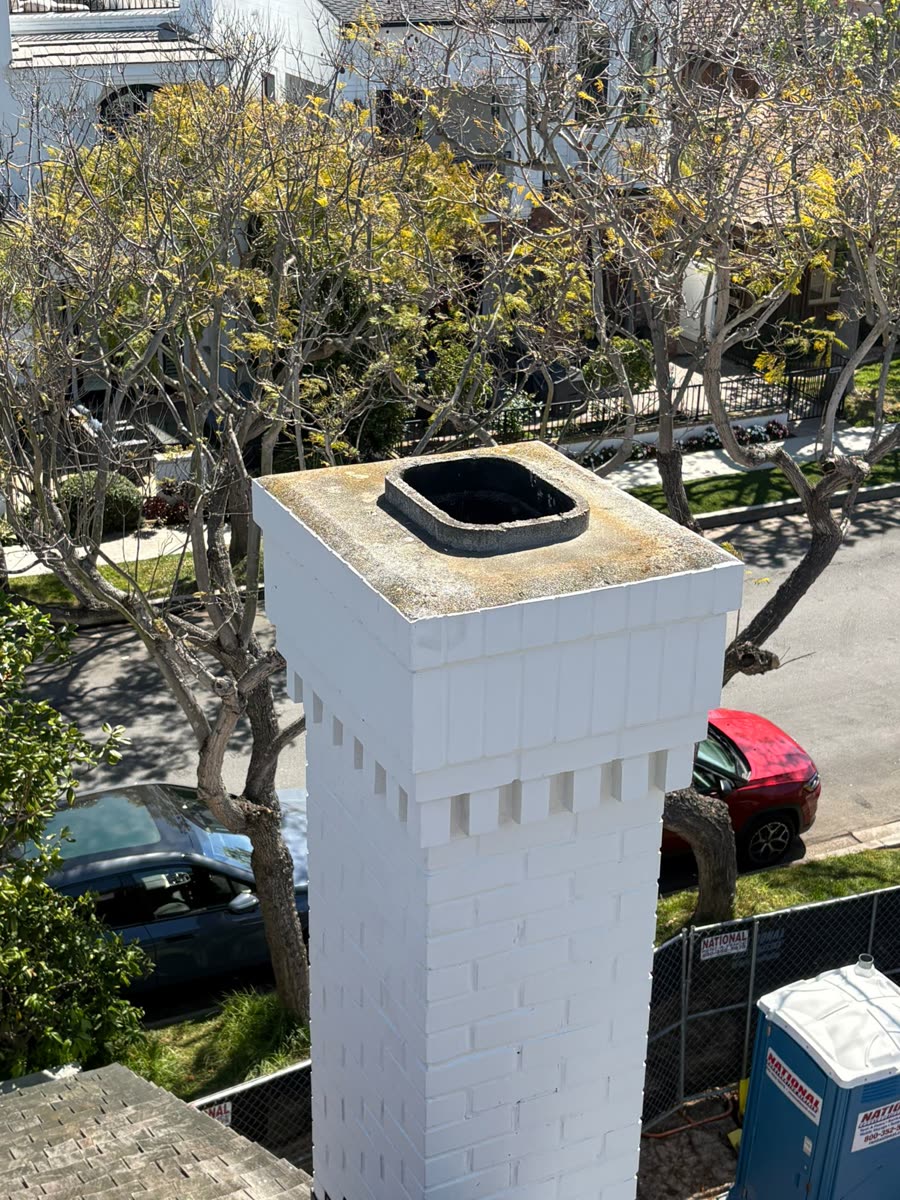 White chimney with a newly installed black cap