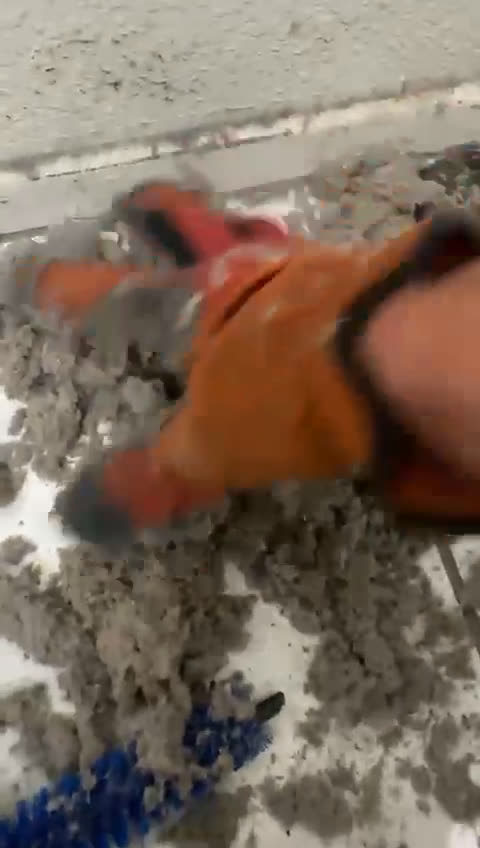 A gloved hand holding a large clump of lint pulled from a dryer vent